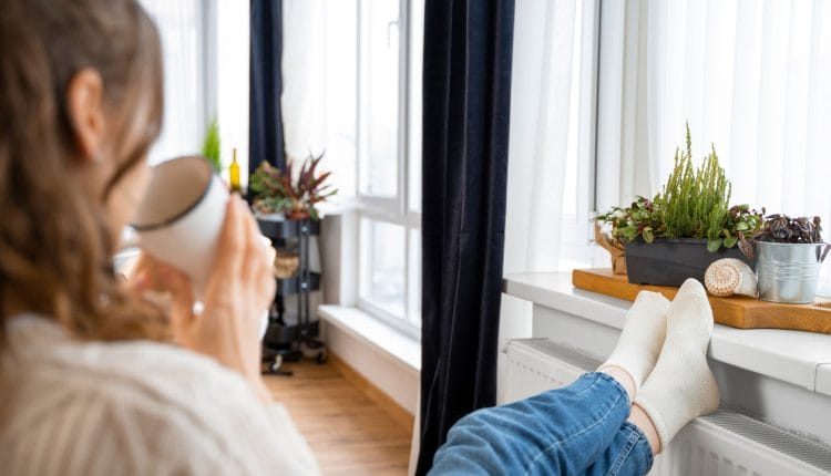 woman sitting with her feet up with air purifing plants to combat air pollution in winter