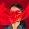 woman with red fabric covering face because she is not able to have conversations about miscarriages, abortions and pregnancy
