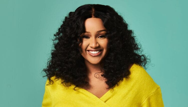 South African podcaster Mpoomy Ledwaba in big curly hair and a yellow sweater