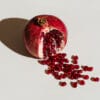 pomegranate on a grey background as a concept for cycle syncing PMS symptoms
